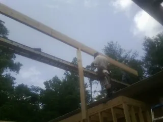 Carpenter setting a ridge beam over a new addition frame — Ice Dam Removal by Roofing Brothers in Aberdeen